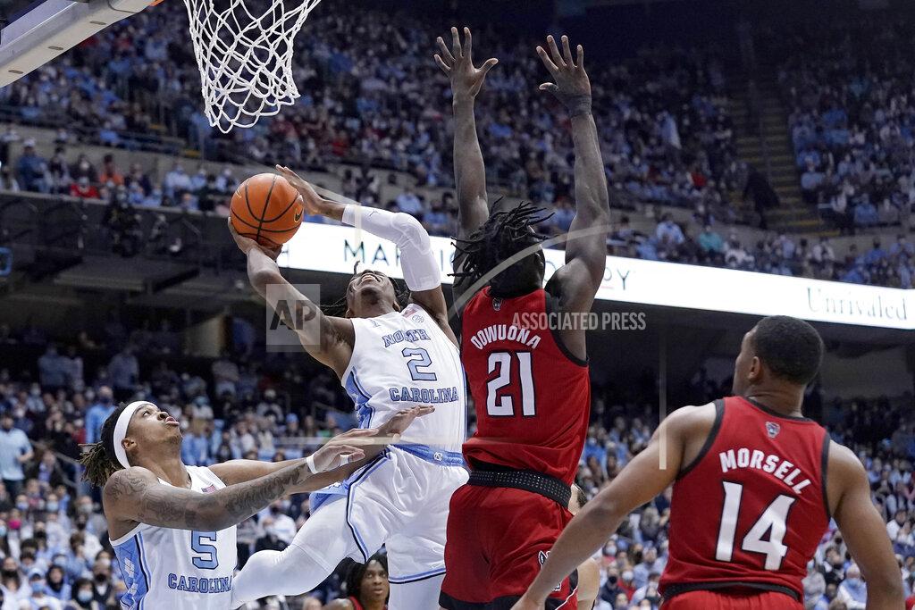 Gerry Broome North Carolina guard Caleb Love (2) drives for a basket against North Carolina State forward Ebenezer Dowuona (21) and guard Casey Morsell (14) while North Carolina forward Armando Bacot (5) looks on during the first half of an NCAA college basketball game in Chapel Hill, N.C., Saturday, Jan. 29, 2022. (AP Photo/Gerry Broome)