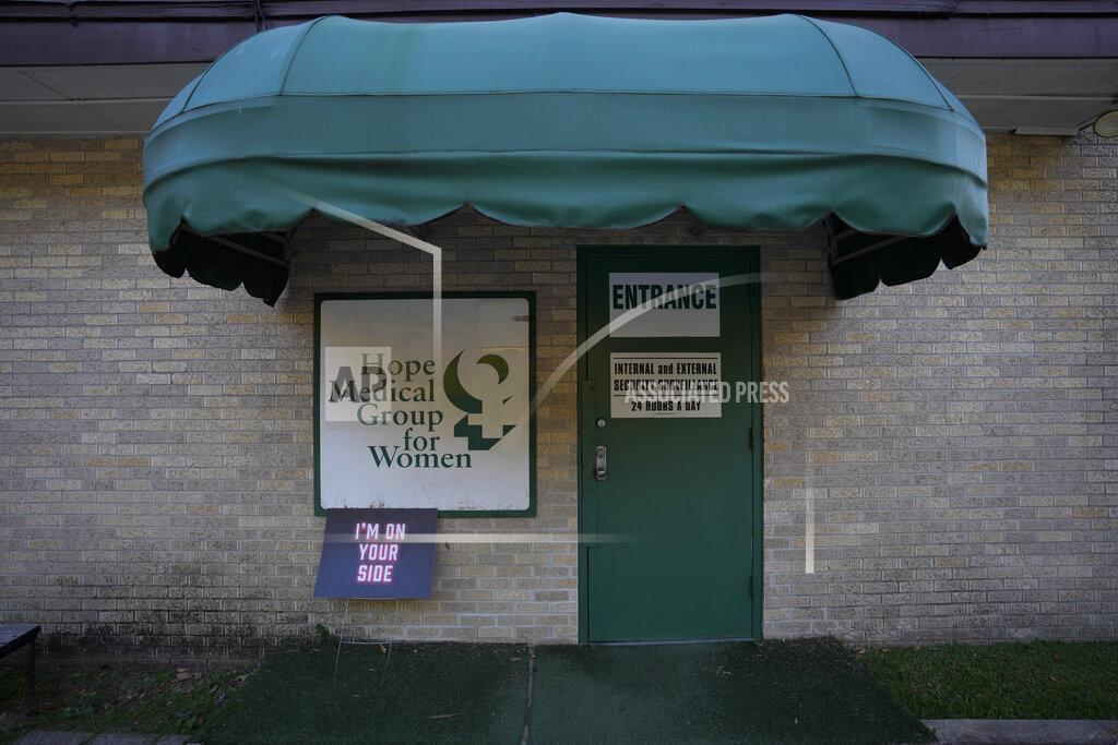 Rebecca Blackwell A sign supporting women seeking abortions rests beside the clinic's side door, where all visitors must pass through a security vestibule before being allowed in, Saturday, Oct. 9, 2021, at Hope Medical Group for Women in Shreveport, La. The nation's most restrictive abortion law is driving many women from Texas to seek services in neighboring states. The abortion clinic in Shreveport is among the clinics being inundated. (AP Photo/Rebecca Blackwell)