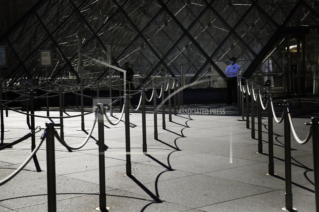 Christophe Ena FILE - In this Tuesday, June 23, 2020 file photo, a guard stands in front of the Louvre museum entrance during a visit ahead of its reopening next July 6, in Paris. After “a very bad year,” Paris tour operator Marc Vernhet sees a ray of light with the promised return of tourists from the United States and elsewhere who are welcome in France as of Wednesday, June 9, 2021 if they have been vaccinated against the coronavirus. (AP Photo/Christophe Ena)