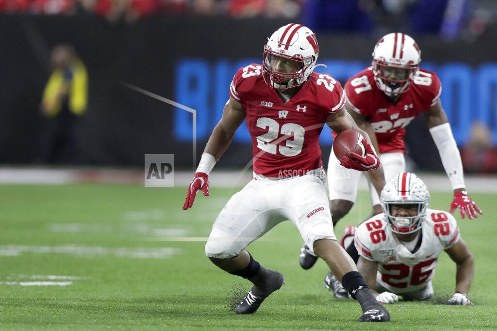 Michael Conroy Wisconsin running back Jonathan Taylor (23) runs during the second half of the Big Ten championship NCAA college football game as Ohio State's Cameron Brown (26) watches Saturday, Dec. 7, 2019, in Indianapolis. (AP Photo/Michael Conroy)