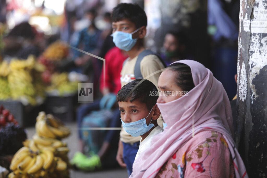Channi Anand Passengers wearing masks as a precaution against the coronavirus wait for transportation at a bus station in Jammu, India, Friday, March 26, 2021.(AP Photo/Channi Anand)