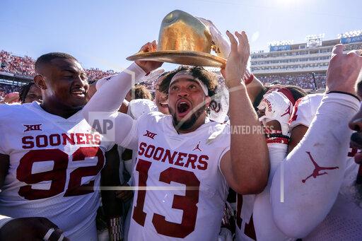 Oklahoma quarterback Caleb Williams (13) puts on the Golden Hat after coming off the bench to lead Oklahoma to a 54-48 win over Texas in an NCAA college football game at the Cotton Bowl, Saturday, Oct. 9, 2021, in Dallas. (AP Photo/Jeffrey McWhorter)