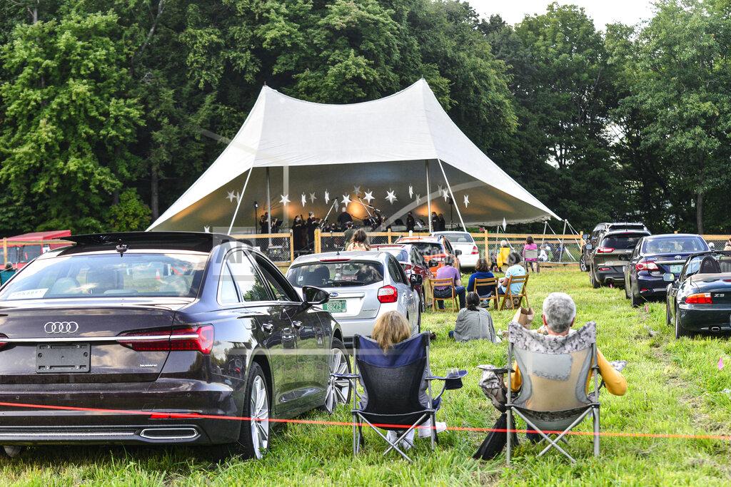 People listen to music played by the Brattleboro Music Center Pops Orchestra during the "Music Under the Stars" drive-in that was hosted by Brattleboro Music Center and Retreat Farm at Harris Hill Ski Jump, in Brattleboro, Vt., Friday, Aug. 28, 2020. This was the first major outside concert held in Brattleboro during the COVID-19 pandemic. (Kristopher Radder/The Brattleboro Reformer via AP)