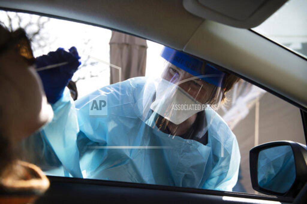 Joe Lamberti FILE - In this April 1, 2020, file photo, a nurse with Cooper administers a test for the new coronavirus at a drive-thru site in Cherry Hill, N.J. (Joe Lamberti/Camden Courier-Post via AP, File)