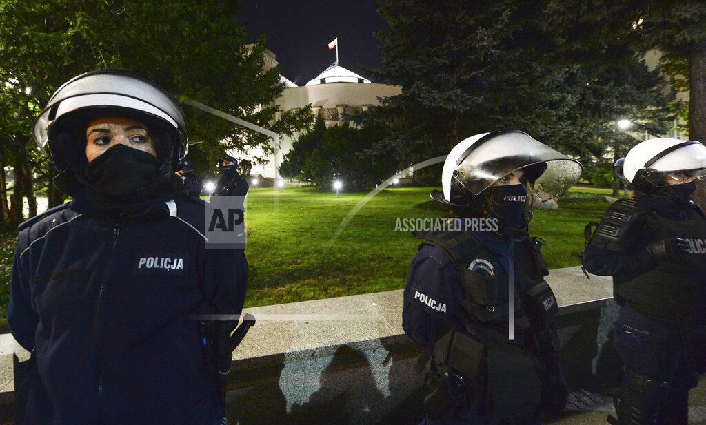 Czarek Sokolowski Police stand guard while protesters block the parliament in Warsaw, Poland, Wednesday Oct. 28, 2020. People across Poland stayed off their jobs and huge crowds poured onto the streets for a seventh straight day of protests Wednesday, enraged over a top court ruling that bans abortions in cases of fetal abnormalities. (AP Photo/Czarek Sokolowski)
