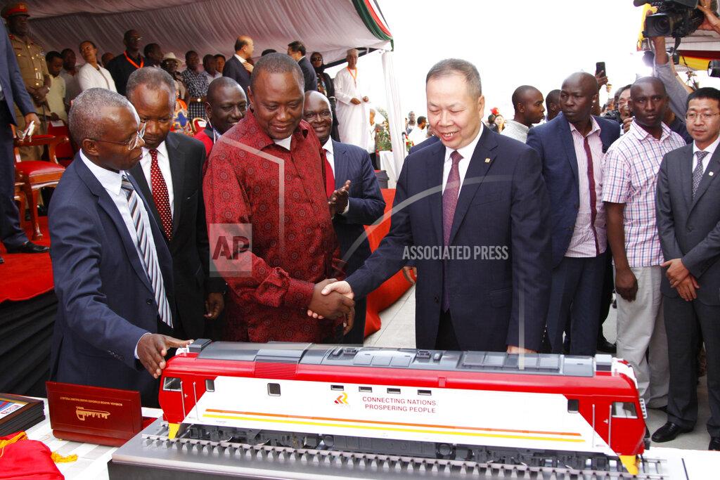 Khalil Senosi FILE - In this Tuesday, May 30, 2017 file photo, Kenya's President Uhuru Kenyatta, center-left, and chairman of China Railway Construction Corporation Chen Fenjian, center-right, shake hands next to a model of a train for the opening of the country's largest infrastructure project, a Chinese-backed railway, in Mombasa, Kenya. African leaders in 2020 are asking what China can do for them as the coronavirus pandemic threatens to destroy economies across a continent where Beijing is both the top trading partner and top lender. (AP Photo/Khalil Senosi, File)