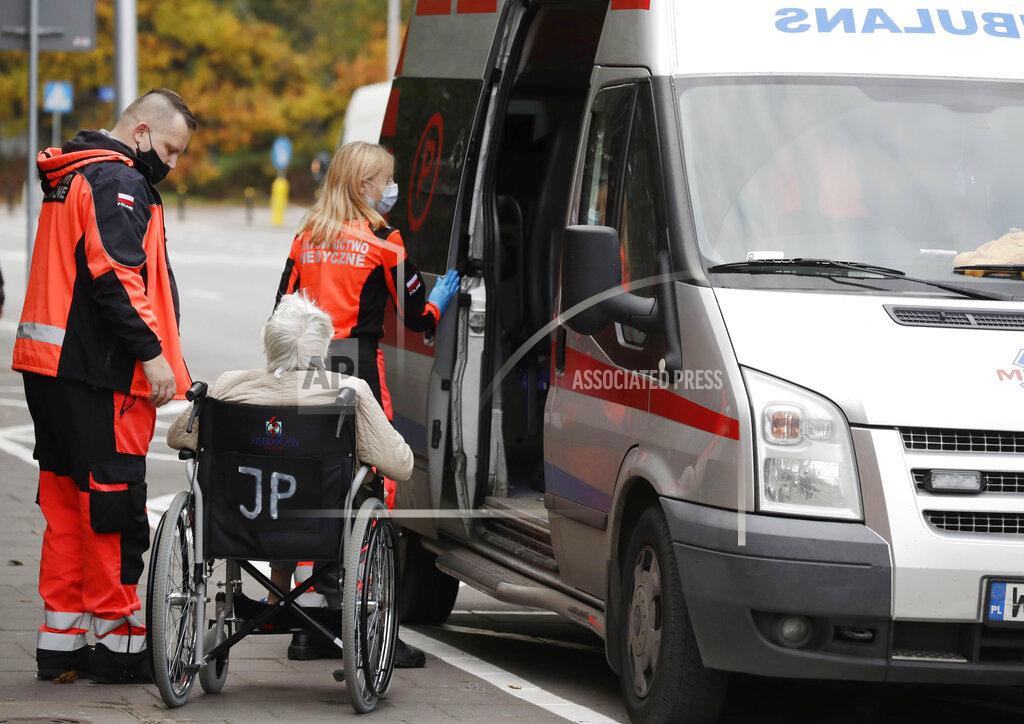 An ambulance brings a COVID-19 patient to a specialized hospital in Warsaw, Poland, on Tuesday, Oct. 20, 2020. Poland is seeing a sharp spike in new cases daily of coronavirus infections, filling up hospital beds. Poland's government is transforming the National Stadium in Warsaw into a field hospital to handle the surging number of people infected with the coronavirus, and expects it to be operational within days, officials said. (AP Photo/Czarek Sokolowski)