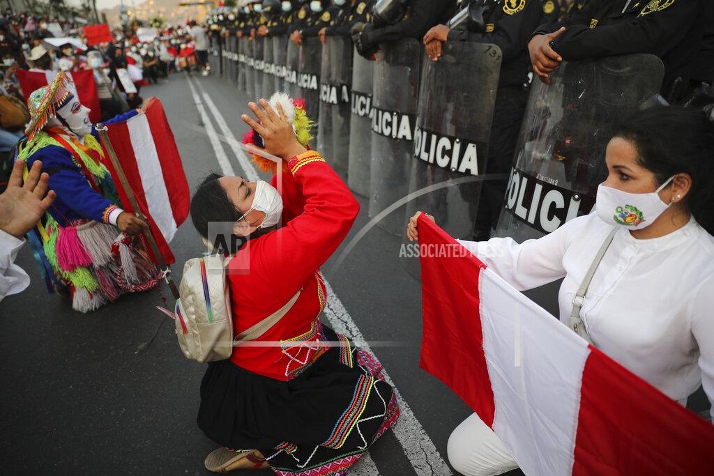 Rodrigo Abd Local folk artists perform next to a police line outside the Congress building, as they wait for news from inside on who will be the country's next president, in Lima, Peru, Sunday, Nov. 15, 2020. Interim President Manuel Merino announced his resignation following massive protests unleashed when lawmakers ousted President Martin Vizcarra. (AP Photo/Rodrigo Abd)