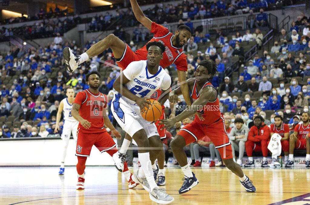 Rebecca S. Gratz Creighton's Arthur Kaluma (24) sets up a shot while under pressure from St. John's Aaron Wheeler, top, and O'Mar Stanley (4) during the first half of an NCAA college basketball game Wednesday, Jan. 19, 2022, in Omaha, Neb. (AP Photo/Rebecca S. Gratz)
