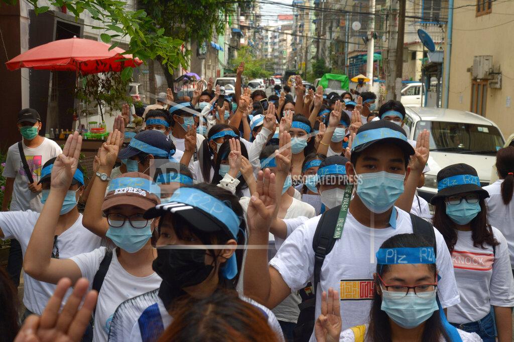 Uncredited Anti-coup protesters flash the three-fingered salute while wearing headbands that read R2P, which means Responsibility to Protect, during a gathering in Ahlone township in Yangon, Myanmar Monday, April 12, 2021. The protesters have called for foreign intervention to aid them under the doctrine of Responsibility to Protect, or R2P, devised to deal with matters such as genocide, war crimes, ethnic cleansing and crimes against humanity. (AP Photo)