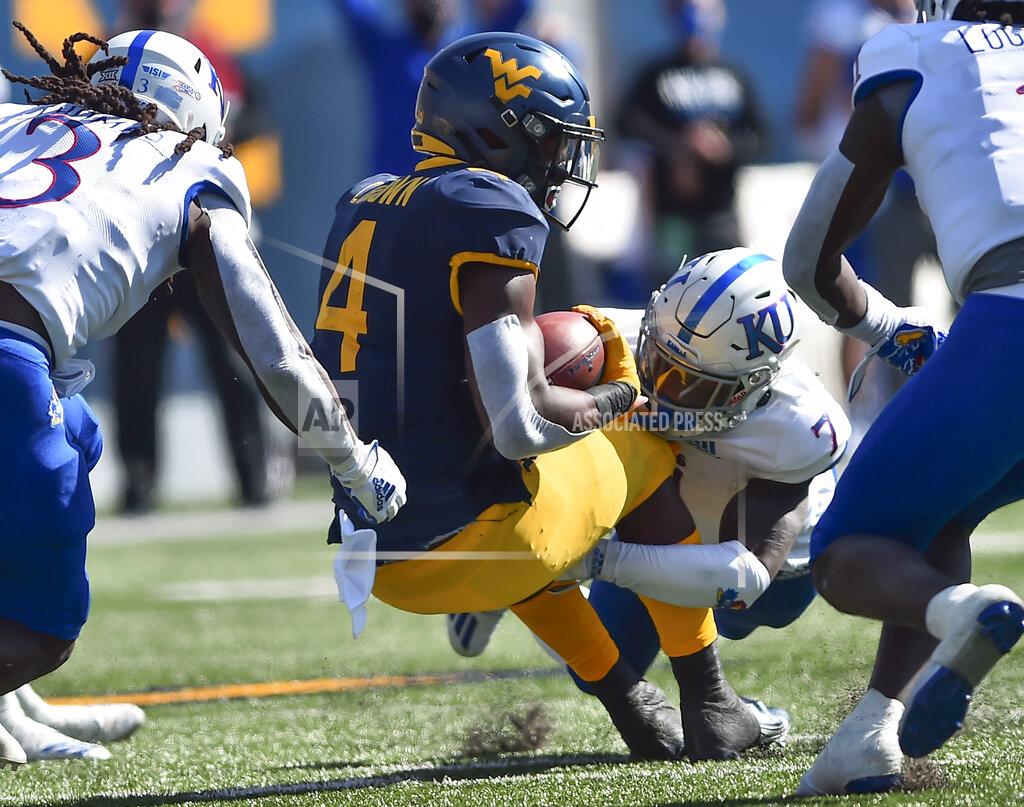 William Wotring West Virginia running back Leddie Brown (4) is tackled by Kansas safety Davon Ferguson (7) during an NCAA college football game, Saturday, Oct. 17, 2020, in Morgantown, W.Va. (William Wotring/The Dominion-Post via AP)
