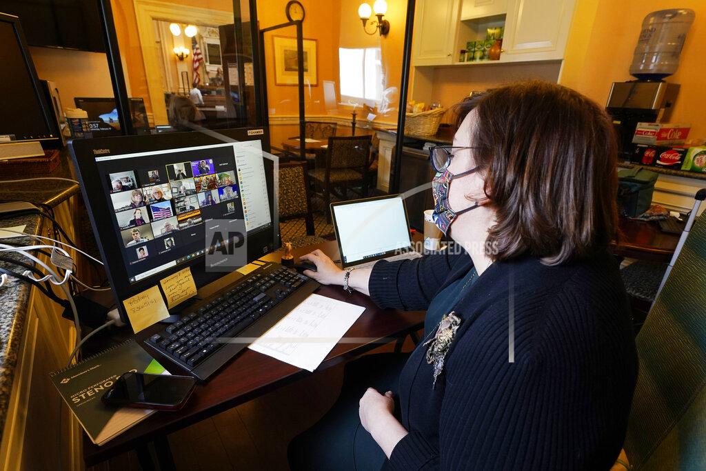 Steve Helber Deputy Clerk for Information Technology, Sharon Steidel, monitors a Virginia House of Delegates Zoom Legislative session off the chambers floor at the Capitol in Richmond, Va., Wednesday, Feb. 10, 2021. (AP Photo/Steve Helber)