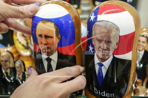 A customer shows to photographer a traditional Russian wooden dolls called Matreska of Russian President Vladimir Putin, center, and U.S. President Joe Biden, center right, at a souvenirs store in Moscow, Russia, Monday, Dec. 6, 2021. The Kremlin says President Joe Biden and Russian President Vladimir Putin will speak in a video call Tuesday. (AP Photo/Pavel Golovkin)