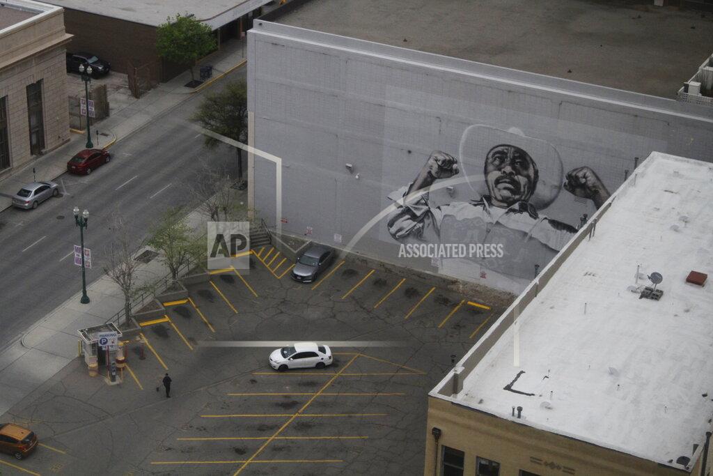 Cedar Attanasio In this Wednesday, March 18, 2020 photo, a woman sweeps a nearly empty parking lot in downtown El Paso, Texas, as seen from the office building of Congresswoman Veronica Escobar, D-Texas. Traffic slowed in the city after sweeping measures to reduce the spread of COVID-19. After closing her office to in-person visits, Escobar held a virtual town hall for constituents to ask questions about government's response to the coronavirus. (AP Photo/Cedar Attanasio)