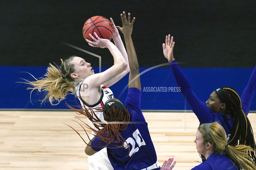 Eric Gay FILE - UConn guard Paige Bueckers, left, drives to the basket against High Point during the first half of a college basketball game in the first round of the women's NCAA tournament at the Alamodome in San Antonio, in this Sunday, March 21, 2021, file photo. Bueckers was named to the preseason Associated Press NCAA college basketball All-America team on Tuesday, Oct. 26, 2021. (AP Photo/Eric Gay, File)