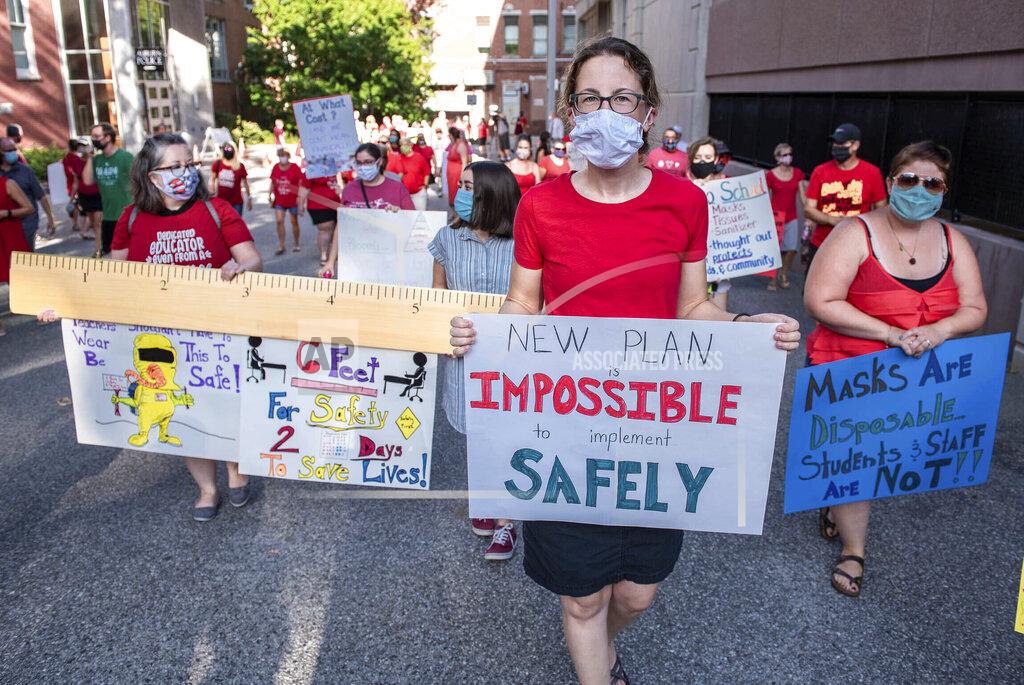 Andree Kehn Abbie Skelton, teacher at Park Avenue School center, walks with other demonstrators from the Auburn School system to participate in a stand-in outside of Auburn City Hall on Wednesday, Aug. 12, 2020. (Andree Kehn/Sun Journal via AP)