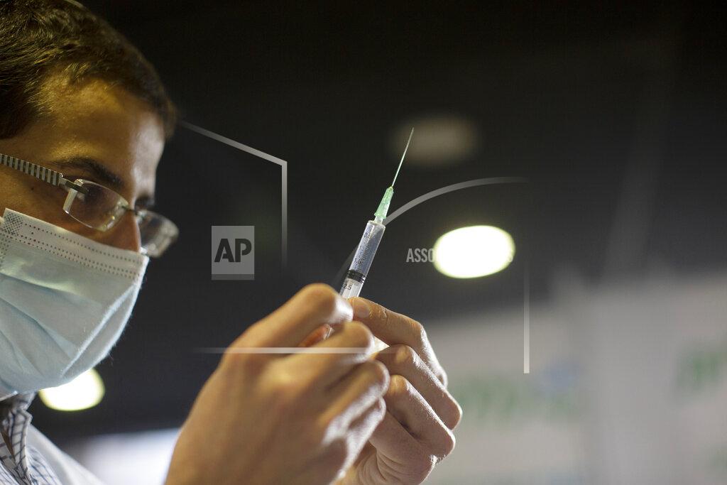 Maya Alleruzzo A medical professional prepares a syringe to administer the coronavirus vaccine a sports arena in Jerusalem, Wednesday, Dec. 30, 2020. (AP Photo/Maya Alleruzzo)