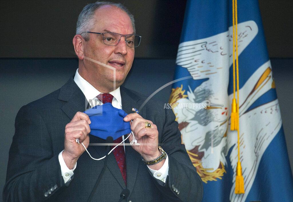 Travis Spradling Louisiana Gov. John Bel Edwards holds up his own mask, taken off while he was speaking, to remind Louisiana residents that a highly effective thing within their power to do to prevent the spread of COVID-19 is to simply wear a mask, Tuesday, July 28, 2020, at a press conference update on the state's COVID-19 situation at the Governor's Office of Homeland Security and Emergency Preparedness in Baton Rouge, La. (Travis Spradling/The Advocate via AP, Pool)
