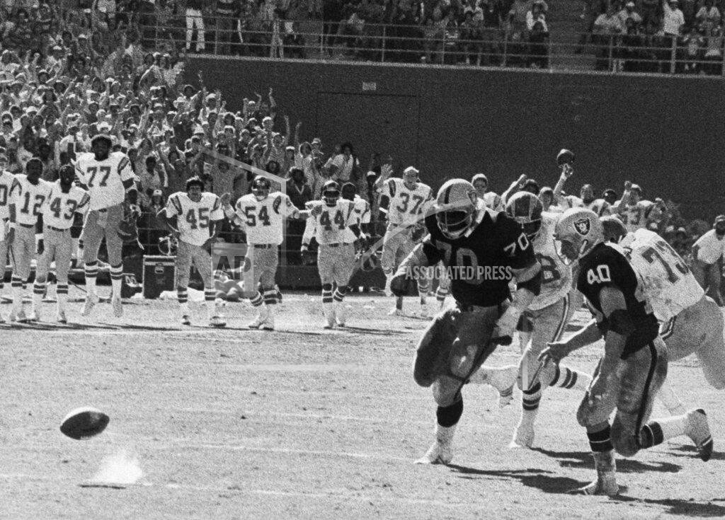 Thane Mcintosh FILE - In this Sept. 11, 1978, file photo, Oakland Raiders Henry Lawrence (70) and Pete Banaszak (40) chase the bouncing ball during a football game against the San Diego Chargers, in San Diego. The stage was set in San Diego on Sept. 10, 1978, when the Raiders had the ball at the Chargers 14, trailing 20-14 with 10 seconds left. Ken Stabler dropped back to pass and was pressured by Chargers linebacker Woodrow Lowe. With nowhere to throw the ball, Stabler either fumbled or pushed the ball forward on purpose, depending on which side of the rivalry is telling the story. Teammate Pete Banaszak then knocked the ball further ahead from about the 13-yard line as it rolled toward the end zone. Tight end Dave Casper kicked the ball forward at the 5 and then fell on it in the end zone with no time remaining. (Thane McIntosh/The San Diego Union-Tribune via AP, File)
