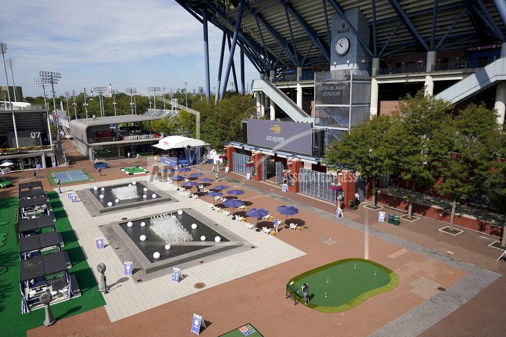 Seth Wenig USTA event personnel walk through the main plaza outside Arthur Ashe Stadium before the second round of the US Open tennis championships, Thursday, Sept. 3, 2020, in New York. The plaza, normally bustling with tennis fans, has been converted into a lounge and playground for the players this year. (AP Photo/Seth Wenig)