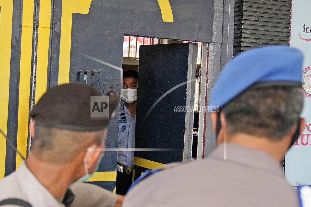 Dita Alangkara Staff and police officers guard the main entrance gate of Tangerang prison in Tangerang on the outskirts of Jakarta, Indonesia, Wednesday, Sept. 8, 2021. A massive fire raged through the overcrowded prison early Wednesday, killing a number of inmates. (AP Photo/Dita Alangkara)
