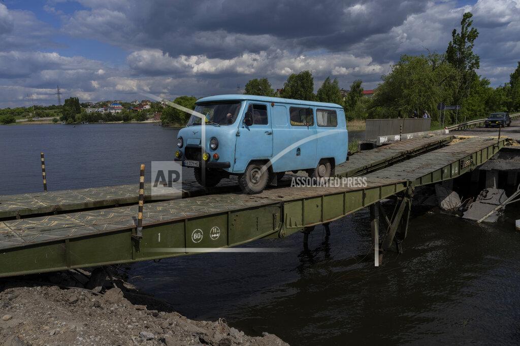 Bernat Armangue A van drives across a bridge repaired in Vilkhivka, outside Kharkiv, in eastern Ukraine, Friday, May 20, 2022. (AP Photo/Bernat Armangue)
