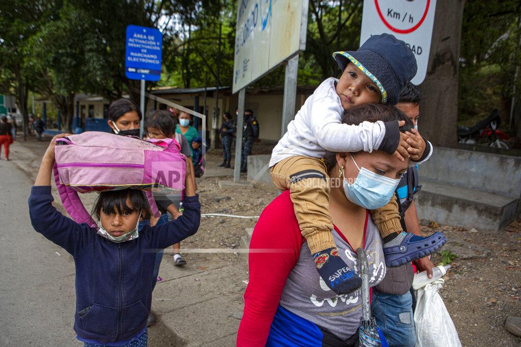 Oliver De Ros Honduran migrants walk to the border crossing after being transported in an army truck to El Florido, Guatemala, a border point between Guatemala and Honduras, Tuesday, Jan. 19, 2021. A once large caravan of Honduran migrants that pushed its way into Guatemala last week had dissipated by Tuesday in the face of Guatemalan security forces. (AP Photo/Oliver de Ros)