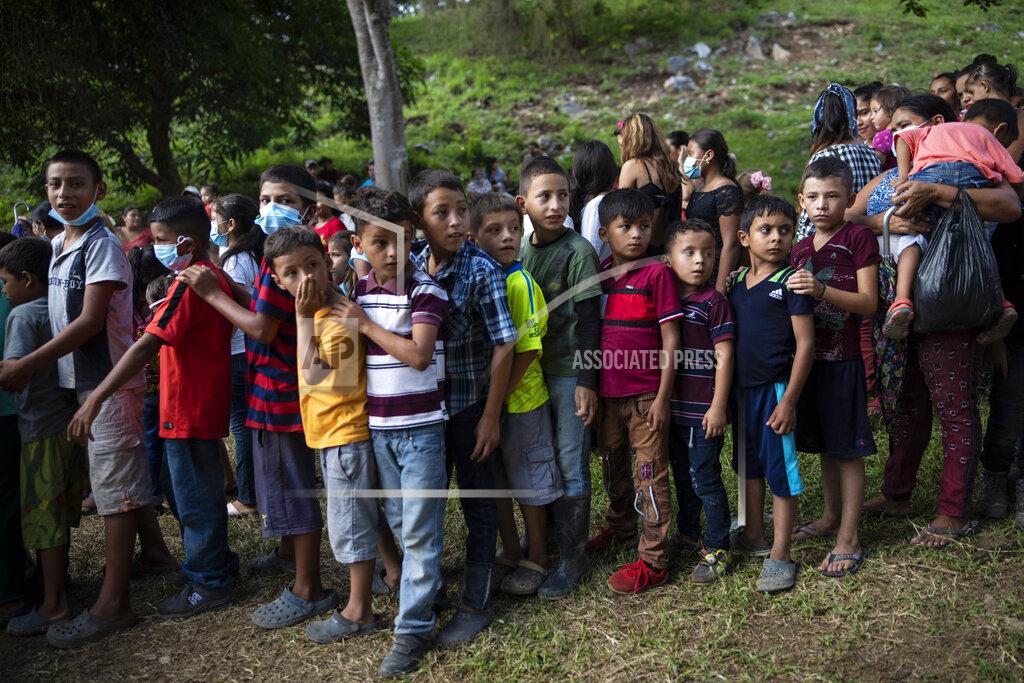 Rodrigo Abd Children wait in line to receive donated used toys at a ceremony with government officials who arrived to open envelopes containing the bids from companies seeking to build homes for the victims of Hurricane Eta and Iota, in Mission San Francisco de Asis, Honduras, Monday, June 28, 2021. Friar Leopoldo Serrano, who runs the mission, warned the community to be wary: “In Honduras we live a daily storm more damaging than hurricanes, the storm of corruption. The authorities deceive us with false promises. That is why I tell you that I still have doubts about the construction of these houses.” (AP Photo/Rodrigo Abd)