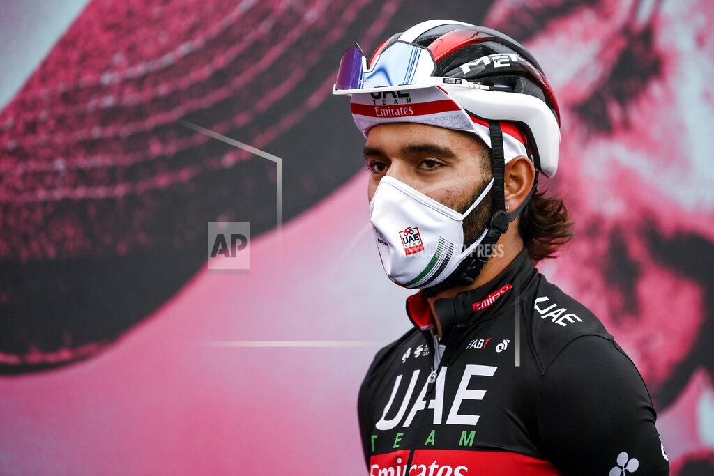 Marco Alpozzi Cyclist Fernando Gaviria wears a face mask to curb the spread of COVID-19 as he attends the 13th stage of the Giro d'Italia cycling race, from Cervia to Monselice, Italy, on Friday, Oct. 16, 2020. Colombian sprinter Gaviria is the latest cyclist to test positive for the coronavirus and be withdrawn from the Giro d’Italia. Gaviria and a staff member for Team AG2R La Mondiale were the only positives out of 492 tests carried out Sunday and Monday, Oct. 19, 2020. (Marco Alpozzi/LaPresse via AP)