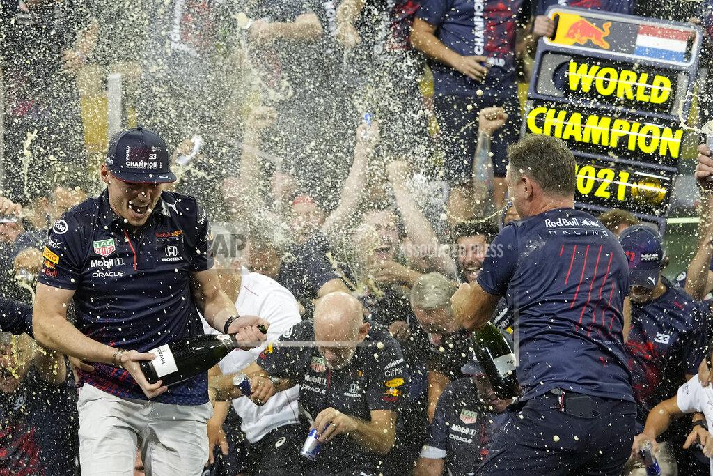 Hassan Ammar Red Bull driver Max Verstappen of the Netherlands, left, celebrates with Red Bull team chief Christian Horner, right, and his team in the pit lane after becoming F1 drivers world champion after winning the Formula One Abu Dhabi Grand Prix in Abu Dhabi, United Arab Emirates, Sunday, Dec. 12. 2021. The most dramatic Formula One season in years ended, of course, in one of the most dramatic finishes possible when Max Verstappen snatched the world championship away from Lewis Hamilton with a pass on the final lap of the Abu Dhabi GP. (AP Photo/Hassan Ammar)