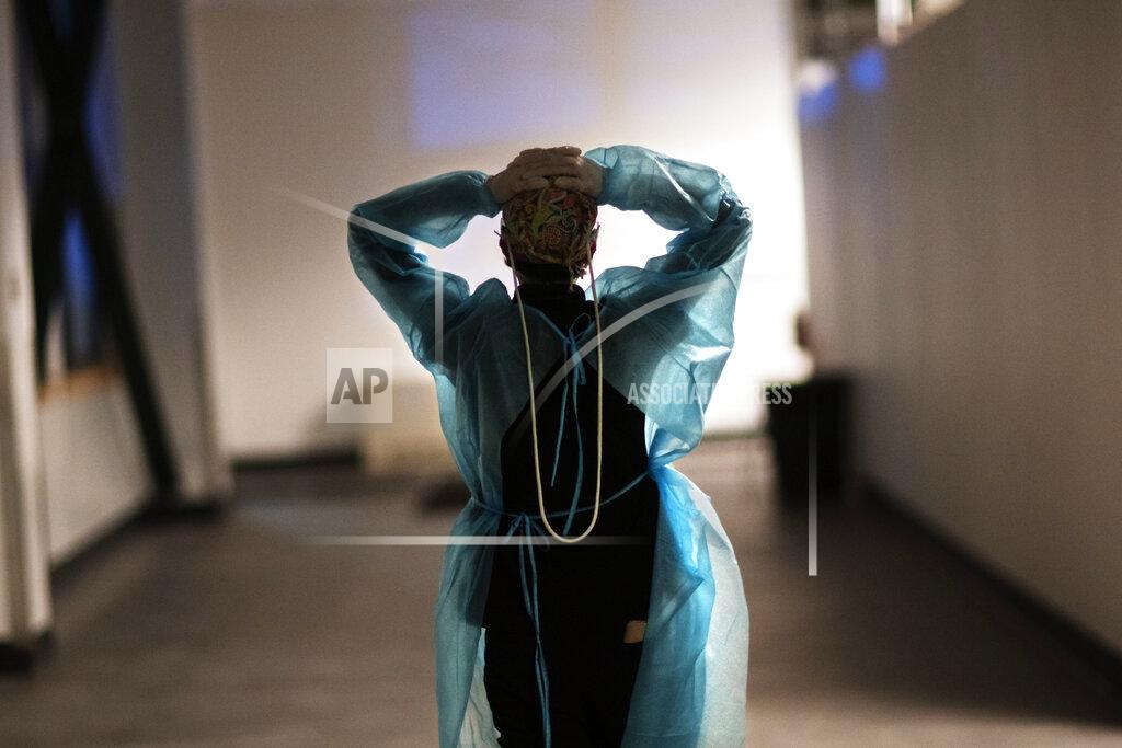 David Goldman Registered traveling nurse Patricia Carrete, of El Paso, Texas, walks down the hallways during a night shift at a field hospital set up to handle a surge of COVID-19 patients, Wednesday, Feb. 10, 2021, in Cranston, R.I. Rhode Island's infection rate has come down since it was the highest in the world two months ago, and many of the field hospital's 335 beds are now empty. On quiet days, the medical staff wishes they could do more. (AP Photo/David Goldman)