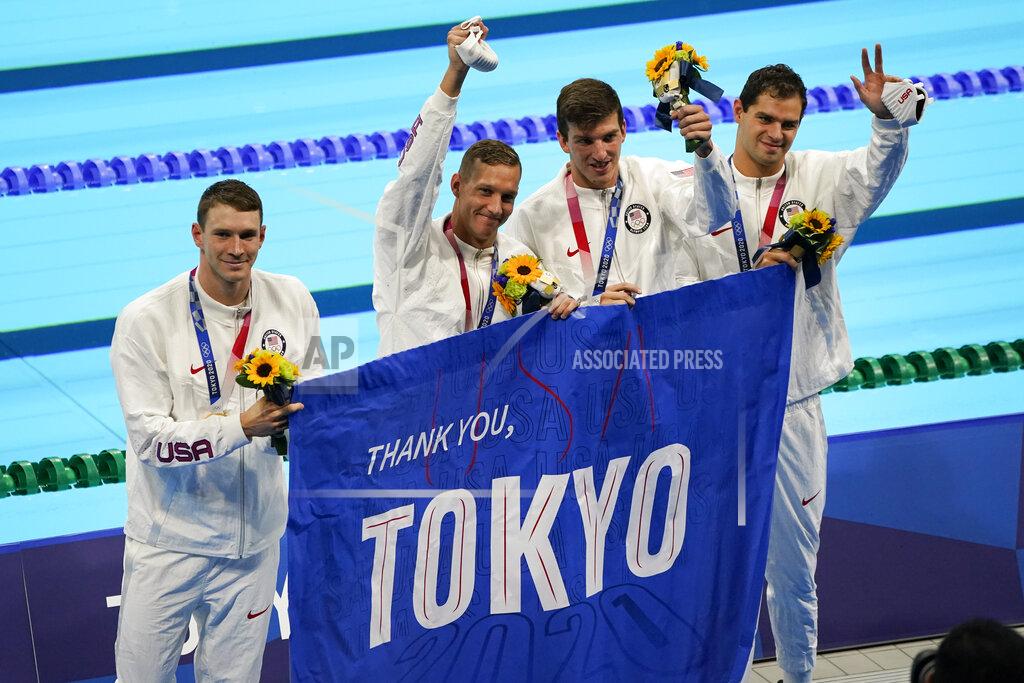 Jae C. Hong FILE - In this Aug. 1, 2021, file photo, members of the U.S. men's 4x100-meter medley relay team, Caeleb Dressel, Zach Apple, Ryan Murphy and Michael Andrew, carry a sign that reads, "Thank you, Tokyo" after winning the gold medal at the 2020 Summer Olympics, in Tokyo, Japan. (AP Photo/Jae C. Hong, File)