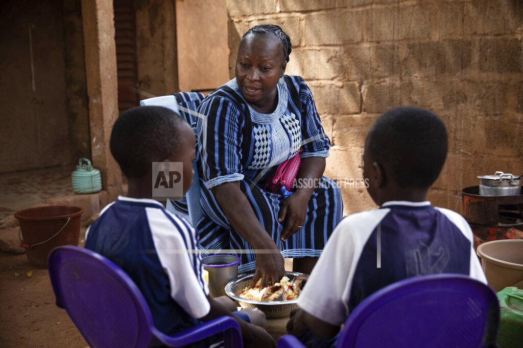 Sophie Garcia Mariama Sawadogo, 44, who works as a radio host at Zama Radio, prepares lunch at her home in Kaya, Burkina Faso, Monday, Oct. 25, 2021. Many guests and listeners in Burkina Faso call her "aunty" as she gently guides them to the right answers and awards prizes such as soap and washing buckets. In the West African country of Burkina Faso, many feel the government has let them down during the pandemic. Tests, vaccines and messaging often miss many residents, despite a $200 million budget for virus-response efforts. In a region where women are responsible for family work and community relationships, they’ve stepped up to fill in gaps. (AP Photo/Sophie Garcia)