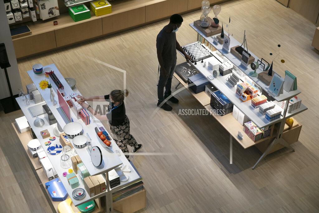 Mark Lennihan Employees at the Museum of Modern Art arrange items in the gift shop, Thursday, Aug. 20, 2020, in New York. MOMA reopens Aug. 27, 2020. (AP Photo/Mark Lennihan)