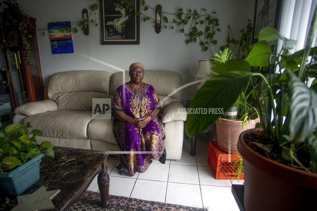 Ivy Ceballo Yochebed Israel, a certified nursing assistant, poses for a portrait inside her Tampa, Fla. apartment on Monday, Aug. 17, 2020. Israel's landlord tried to evict her in violation of the CARES Act after she fell behind on rent after contracting COVID-19. (Ivy Ceballo/Howard Center for Investigative Journalism via AP)