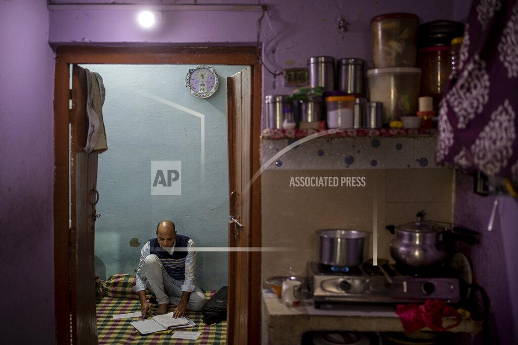 Altaf Qadri Muhammad Nasir Khan, who was shot by a Hindu mob during the February 2020 communal riots, sifts through his legal and medical files inside his home in North Ghonda, one of the worst riot affected neighborhood, in New Delhi, India, Friday, Feb. 19, 2021. As the first anniversary of bloody communal riots that convulsed the Indian capital approaches, Muslim victims are still shaken and struggling to make sense of their struggle to seek justice. (AP Photo/Altaf Qadri)