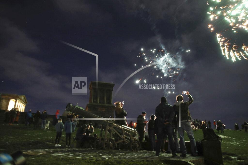 Andrew Milligan People on Calton Hill watch fireworks in Edinburgh as people are urged to avoid Hogmanay celebrations in the midst of tough coronavirus restrictions Thursday Dec. 31, 2020. (Andrew Milligan/PA via AP)