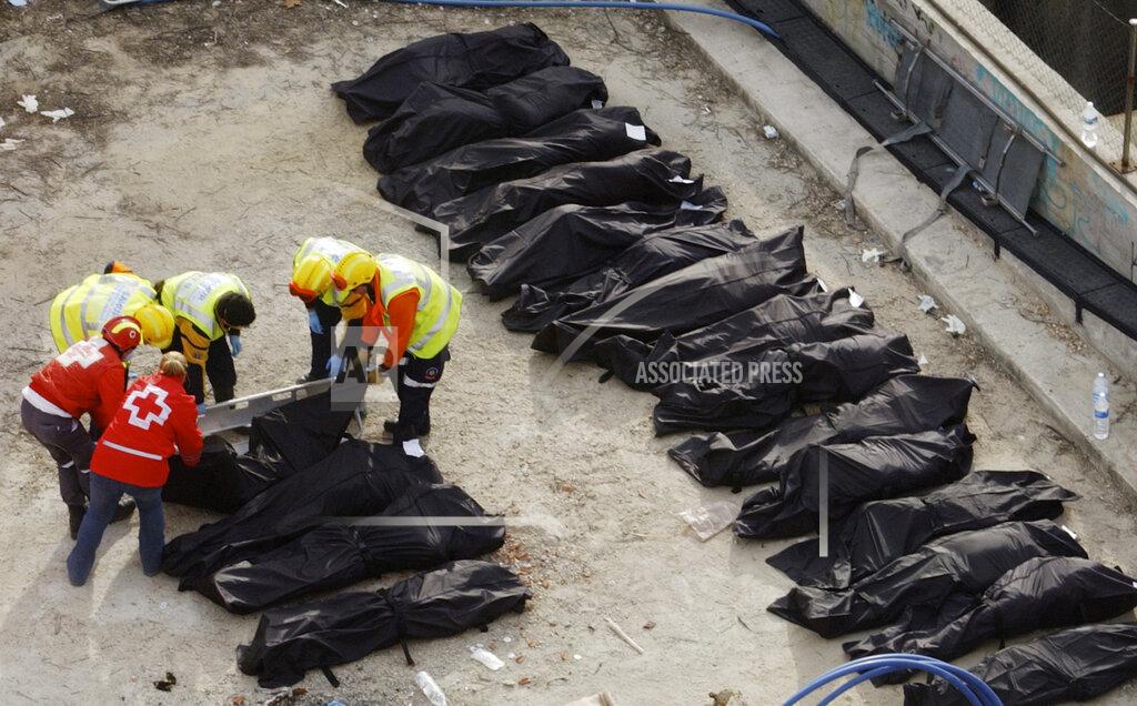 Denis Doyle FILE - In this Thursday, March 11, 2004 file photo, rescue workers line up bodies beside a bomb-damaged passenger train at Atocha station following a series of explosions on trains in Madrid. (AP Photo/Denis Doyle)