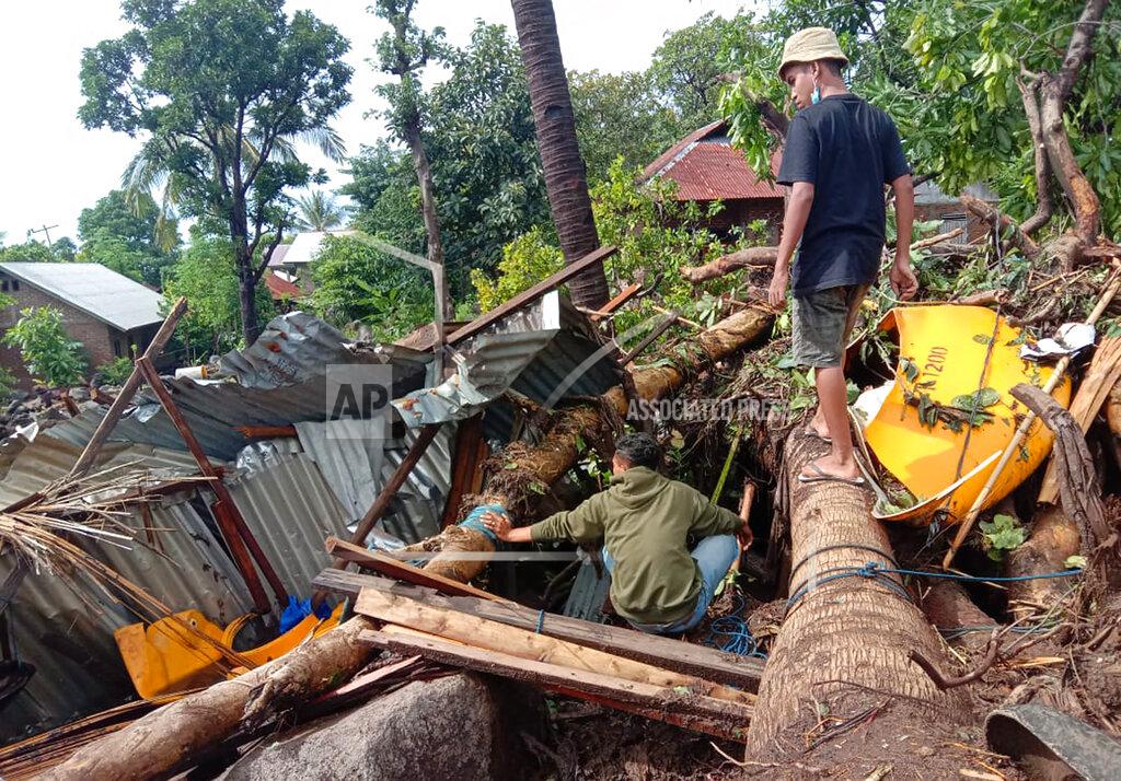 Ricko Wawo Indonesian scavenge usable items from the ruins of their house at a village hit by a landslide in Ile Ape Timur on Lembata Island, East Nusa Tenggara province, Indonesia, Monday, April 5, 2021. Multiple disasters caused by torrential rains in eastern Indonesia and neighboring East Timor have left a number of people dead or missing as rescuers were hampered by damaged bridges and roads and a lack of heavy equipment Monday. (AP Photo/Ricko Wawo)