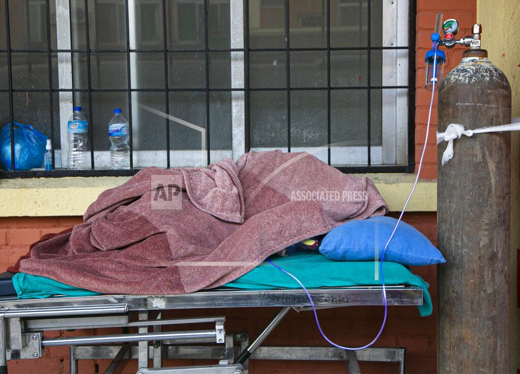 Niranjan Shrestha A COVID-19 patient covered under a blanket receives oxygen outside an emergency ward as she waits for a bed to be allotted at a hospital in Kathmandu, Nepal, Thursday, May 6, 2021. Nepal's main cities and towns including the capital Kathmandu has been in lockdown since last month as the number coronavirus cases and deaths continue to rise. (AP Photo/Niranjan Shrestha)