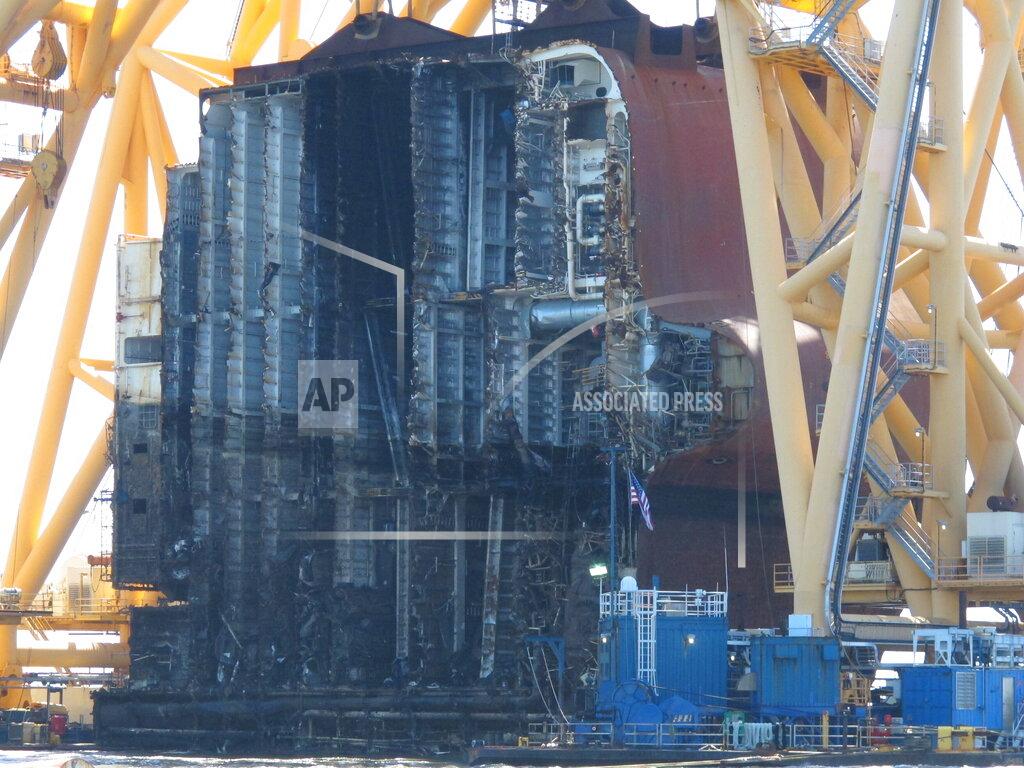 Russ Bynum Interior decks of the capsized cargo ship Golden Ray are exposed on Monday, April 26, 2021, after the engine room section was cut away and separated from the rest of the shipwreck by a towering crane, offshore of St. Simons Island, Ga. The South Korean vessel capsized with roughly 4,200 vehicles in its cargo decks in September 2019. The engine room section is the fourth giant chunk of the ship to be cut away and removed since demolition began in November 2020. (AP Photo/Russ Bynum)