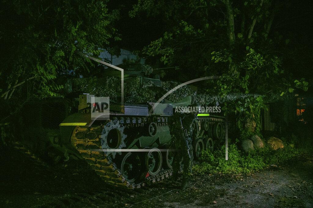 Uncredited In this photo released by the Military News Agency, a soldier and tank prepare for the annual Han Kuang live-fire drills in Hualian, eastern Taiwan in the early hours of Tuesday, Sept. 14, 2021. (Military News Agency via AP)