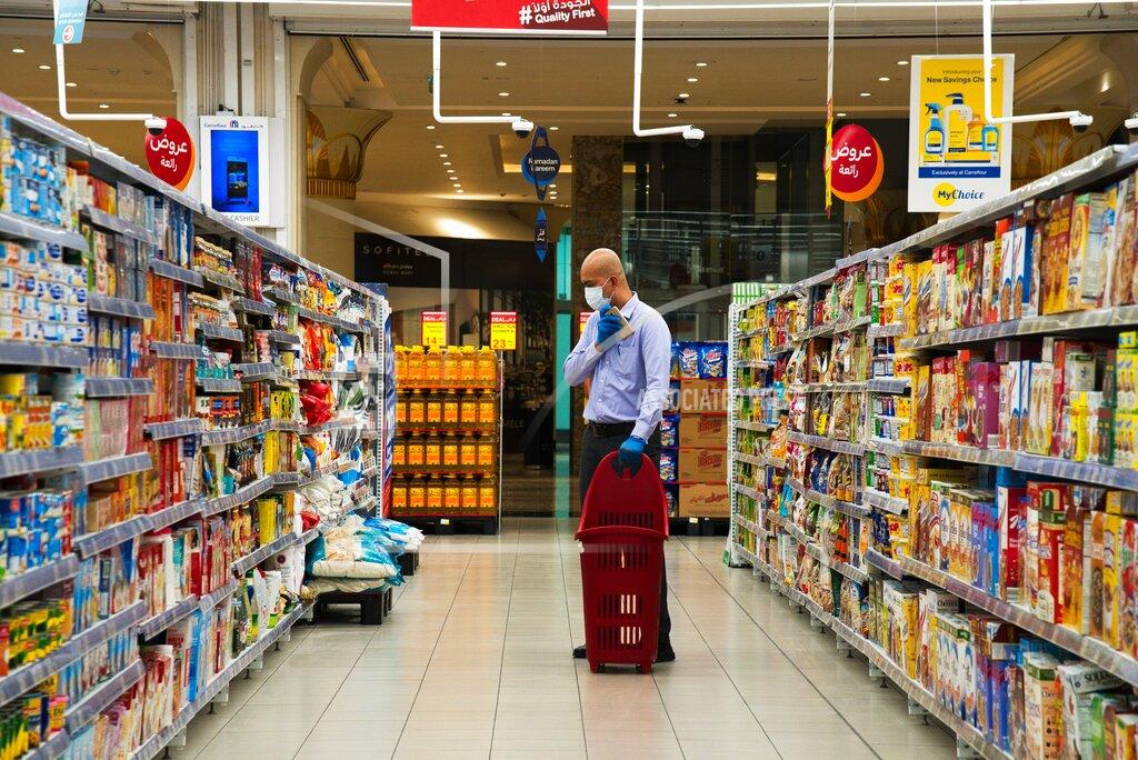 Jon Gambrell In this April 19, 2020 photo, a customer at a Carrefour supermarket wearing a face mask amid the coronavirus pandemic shops in the store in Dubai, United Arab Emirates. Frontline workers across Arab Gulf countries are uniquely almost entirely foreigners. They risk exposure to the novel coronavirus, ensuring patients are cared for, streets are sanitized, packages are delivered and grocery stores are stocked. The global pandemic has drawn attention to just how vital foreigners are to the Arab Gulf countries where they work. (AP Photo/Jon Gambrell)