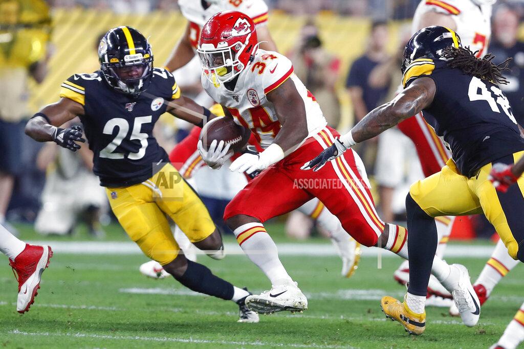Don Wright Kansas City Chiefs running back Carlos Hyde (34) runs between Pittsburgh Steelers outside linebacker Bud Dupree (48) and cornerback Artie Burns (25) in the first half of a preseason NFL football game, Saturday, Aug. 17, 2019, in Pittsburgh. (AP Photo/Don Wright)