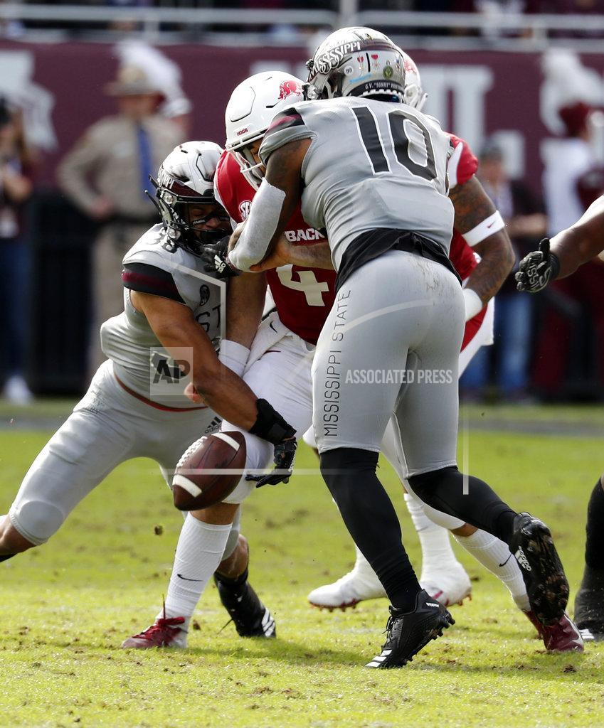 Rogelio V. Solis Arkansas quarterback Ty Storey (4) fumbles the ball after being double teamed by Arkansas defensive back Jayden Minchew (38) and defensive lineman Randy Ramsey (10) during the first half of an NCAA college football game in Starkville, Miss., Saturday, Nov. 17, 2018. Mississippi State won 52-6. (AP Photo/Rogelio V. Solis)