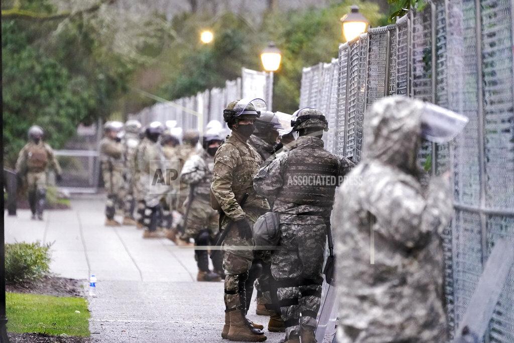 Ted S. Warren Members of the Washington National Guard stand at a fence surrounding the Capitol in anticipation of protests Monday, Jan. 11, 2021, in Olympia, Wash. State capitols across the country are under heightened security after the siege of the U.S. Capitol last week. (AP Photo/Ted S. Warren)