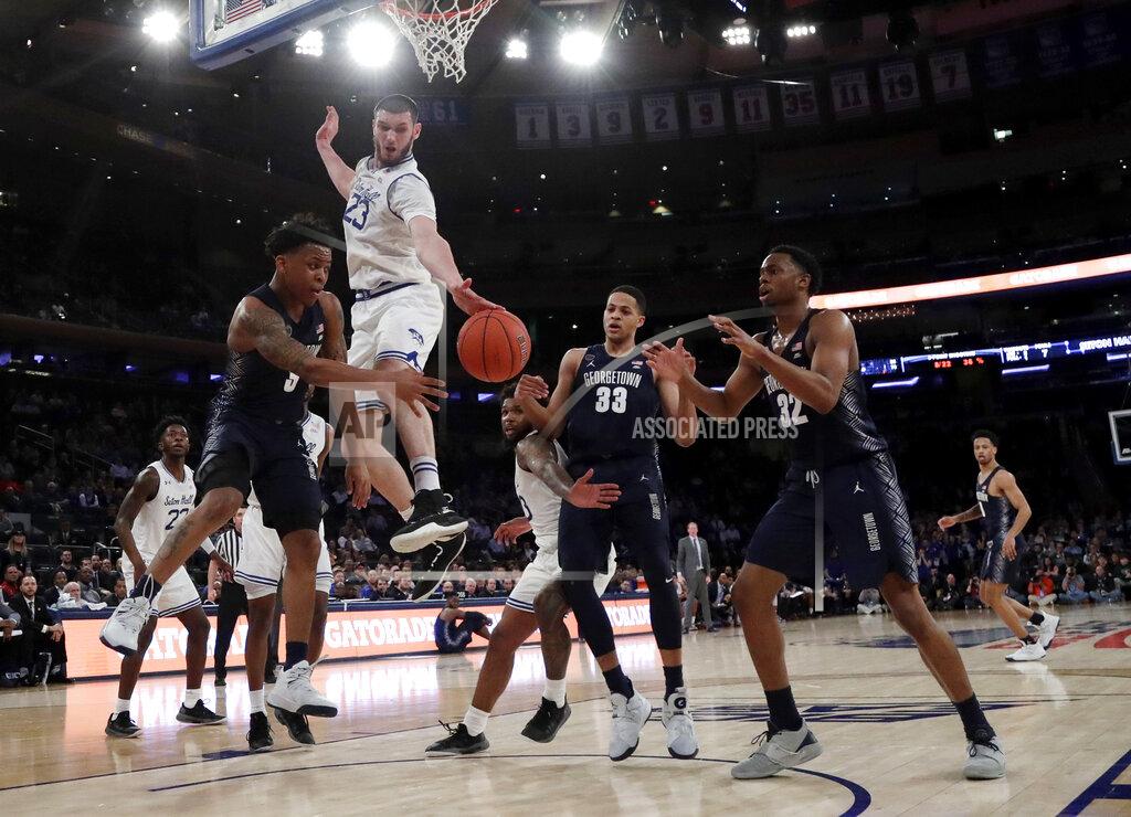 Julio Cortez Georgetown guard James Akinjo, left, tries to pass the ball to teammates Trey Mourning (33) and Kaleb Johnson (32) as Seton Hall forward Sandro Mamukelashvili (23) defends during the second half of an NCAA college basketball game in the Big East men's tournament, Thursday, March 14, 2019, in New York. Seton Hall won 73-57. (AP Photo/Julio Cortez)