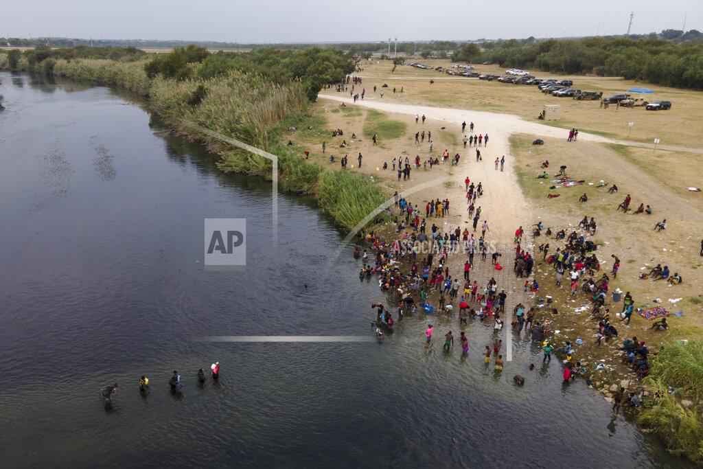 Julio Cortez FILE - In this Sept. 21, 2021, file photo, migrants, many from Haiti, are seen wading between the U.S. and Mexico on the Rio Grande, in Del Rio, Texas. The Border Patrol's treatment of Haitian migrants, they say, is just the latest in a long history of discriminatory U.S. policies and of indignities faced by Black people, sparking new anger among Haitian Americans, Black immigrant advocates and civil rights leaders.(AP Photo/Julio Cortez, File)