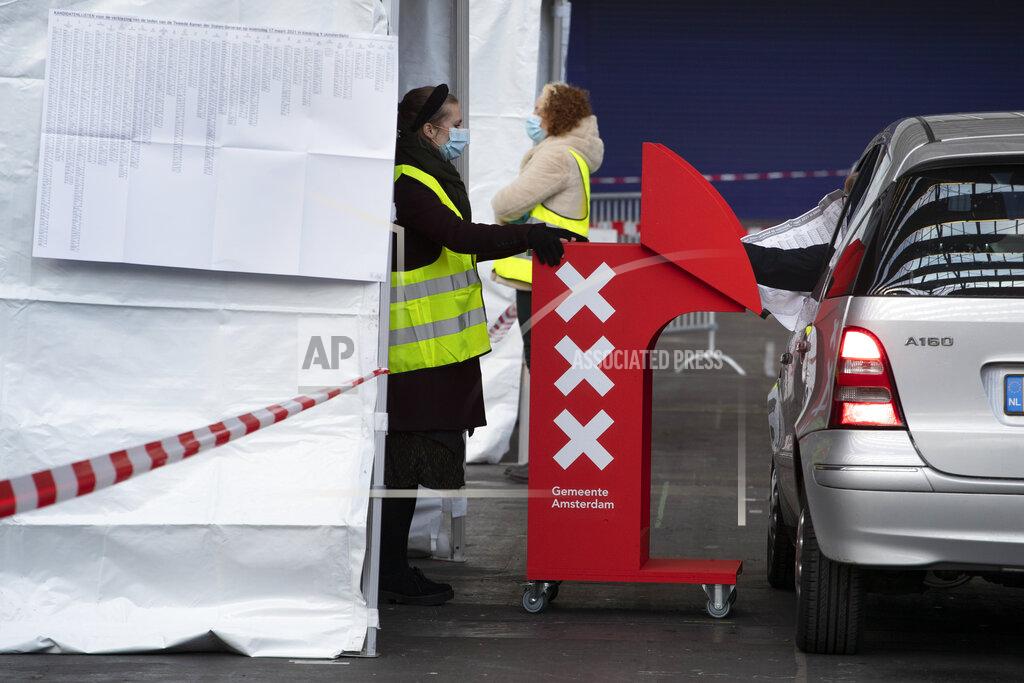 Peter Dejong A person casts his ballot in drive through polling station in Amsterdam, Netherlands, Monday, March 15, 2021. Polling stations opened across the Netherlands early Monday in a general election that has been spread over three days to allow people to vote safely during the coronavirus pandemic. (AP Photo/Peter Dejong)