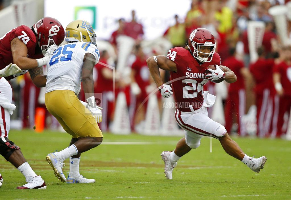 Sue Ogrocki Oklahoma running back Rodney Anderson (24) runs around UCLA linebacker Tyree Thompson (25) in the first half of an NCAA college football game in Norman, Okla., Saturday, Sept. 8, 2018. (AP Photo/Sue Ogrocki)
